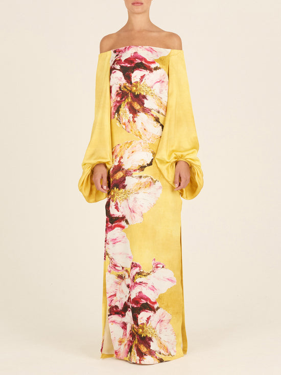 The Lexi Tunic, featuring a floral pattern with canary pink flowers, showcases an off-the-shoulder design and large, gathered sleeve details in yellow.