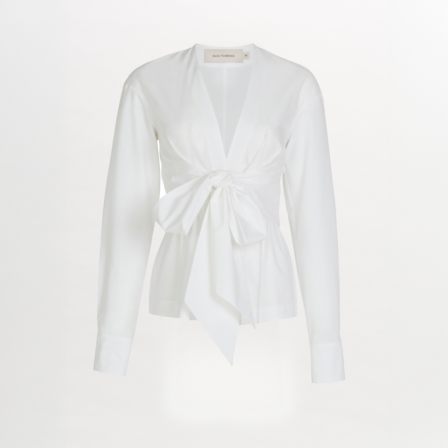 A Saanvi Blouse White with a v-shaped neckline and a bow at the neck.