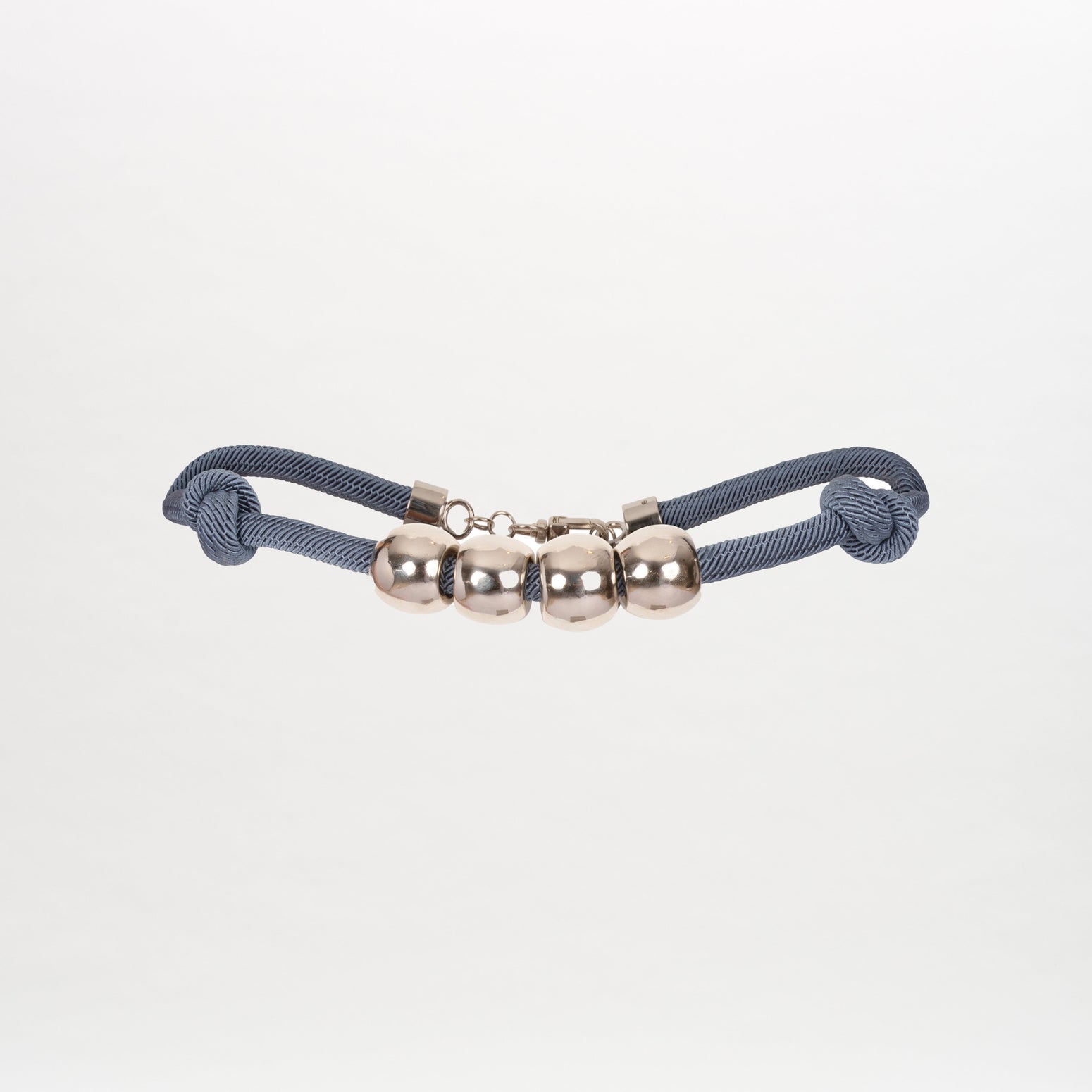 The Sam Belt is a blue cord with silver-tone accents, knotted cord detail, and four evenly spaced metal balls, presented against a plain white background.