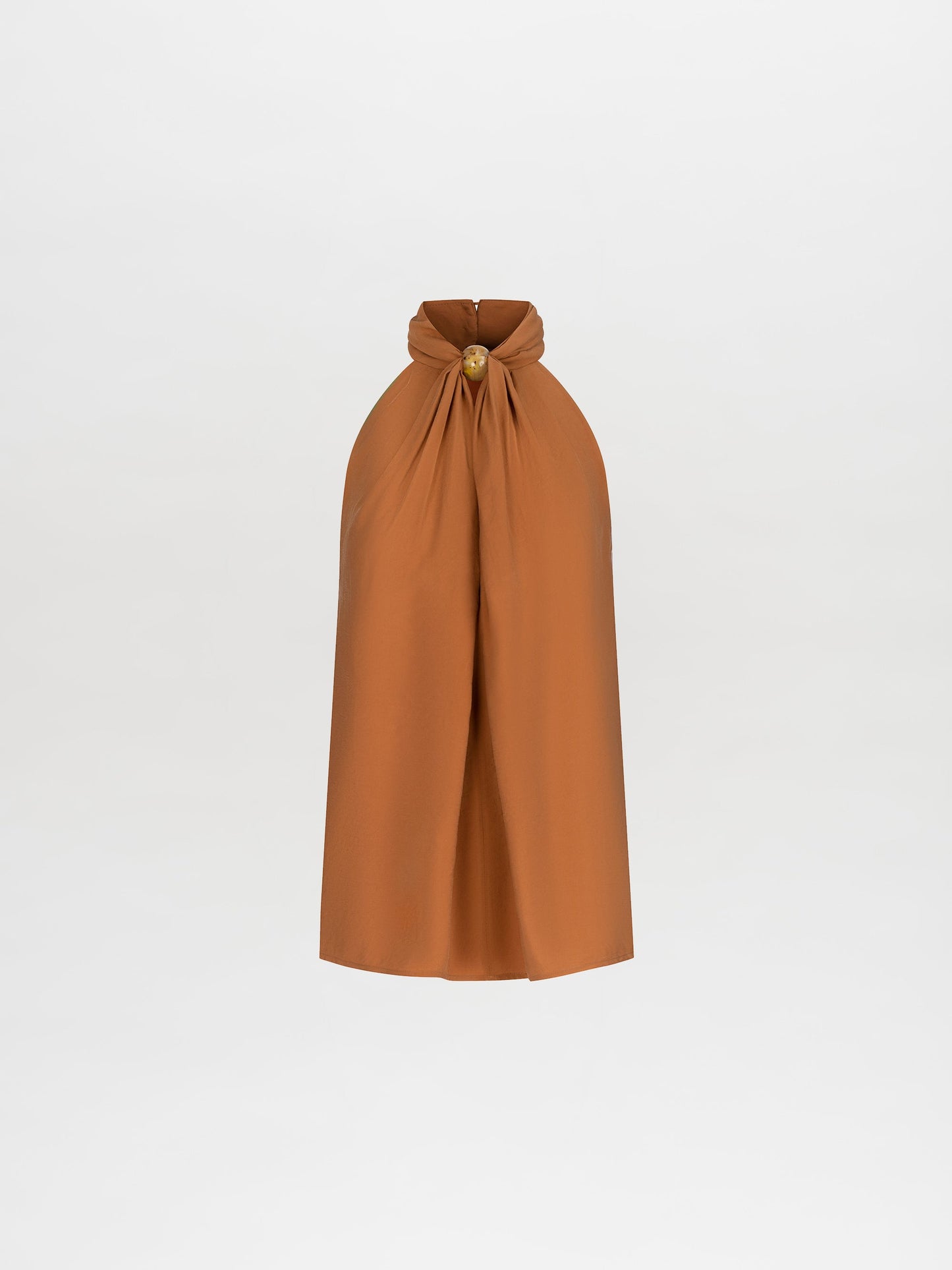 A person wearing the Shela Blouse Camel sleeveless high-neck top with matching wide-leg trousers, accessorized with a belt and holding a small object, stands against a plain white background. Pre-order now to ensure it ships by February 15th, 2025.