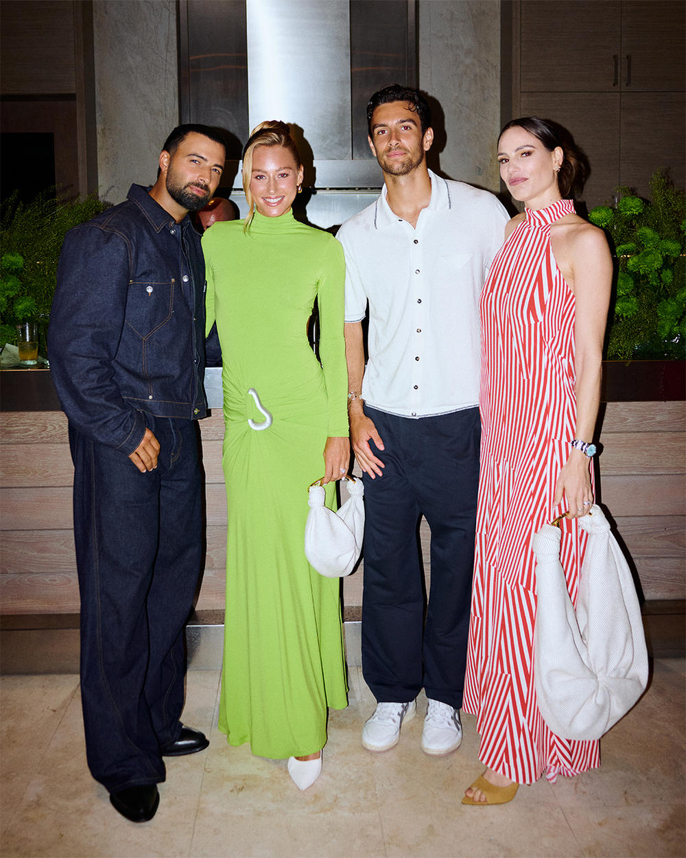 Four people posing together in a modern indoor setting