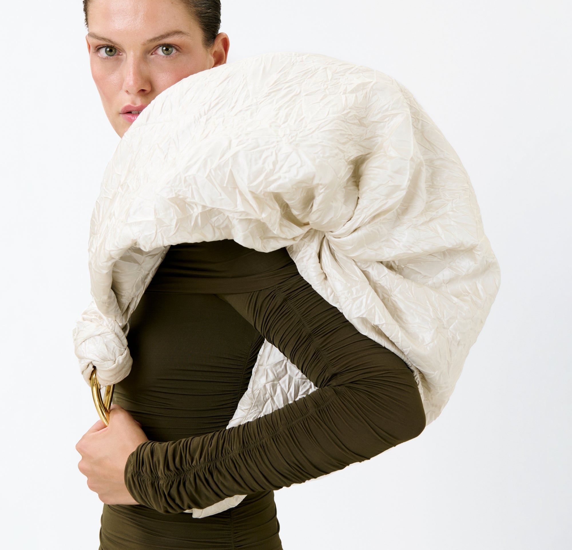 A person in a dark long-sleeve top showcases the Sofia Bag (Maxi), draped over their shoulder for a bold, sculptural look against a plain white background.