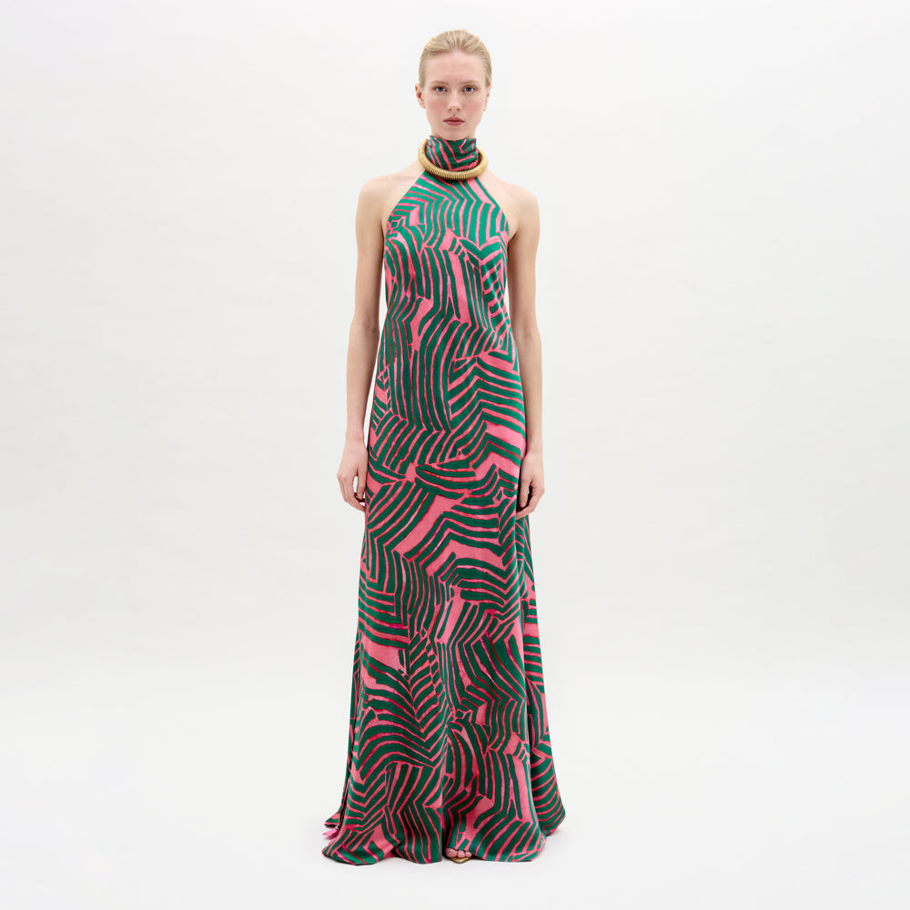 A woman wearing the Tila Dress in color Pink Green Abstract with a golden necklace on a white background.