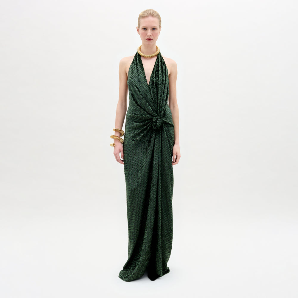 A woman wearing the Torgiano dress in color Hunter greenb with golden accesories on a white background.