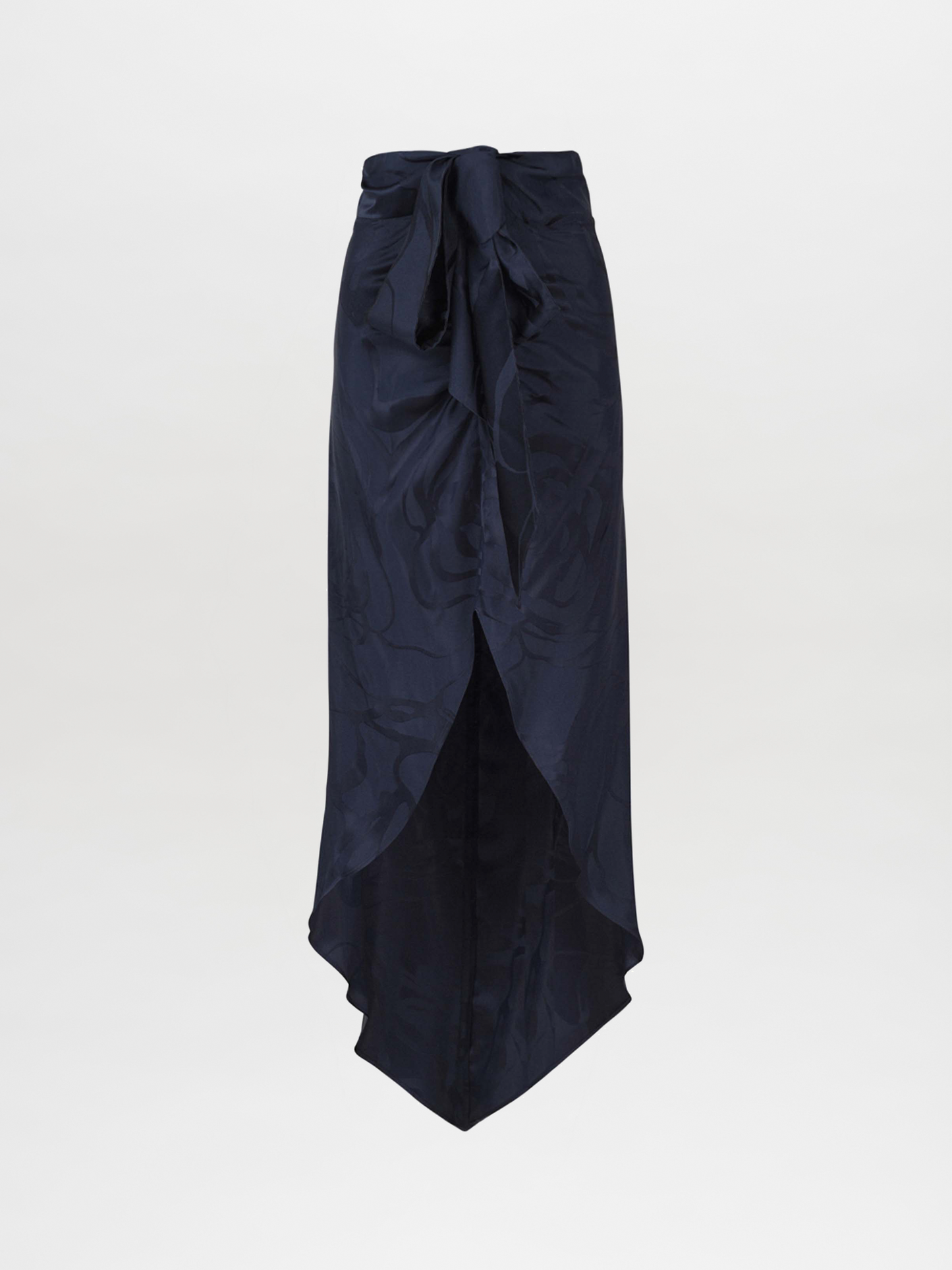 A Tara Skirt Navy Jacquard, featuring a tie at the waist and a mid-length navy floral jacquard design with an asymmetrical hemline, set against a plain white background.