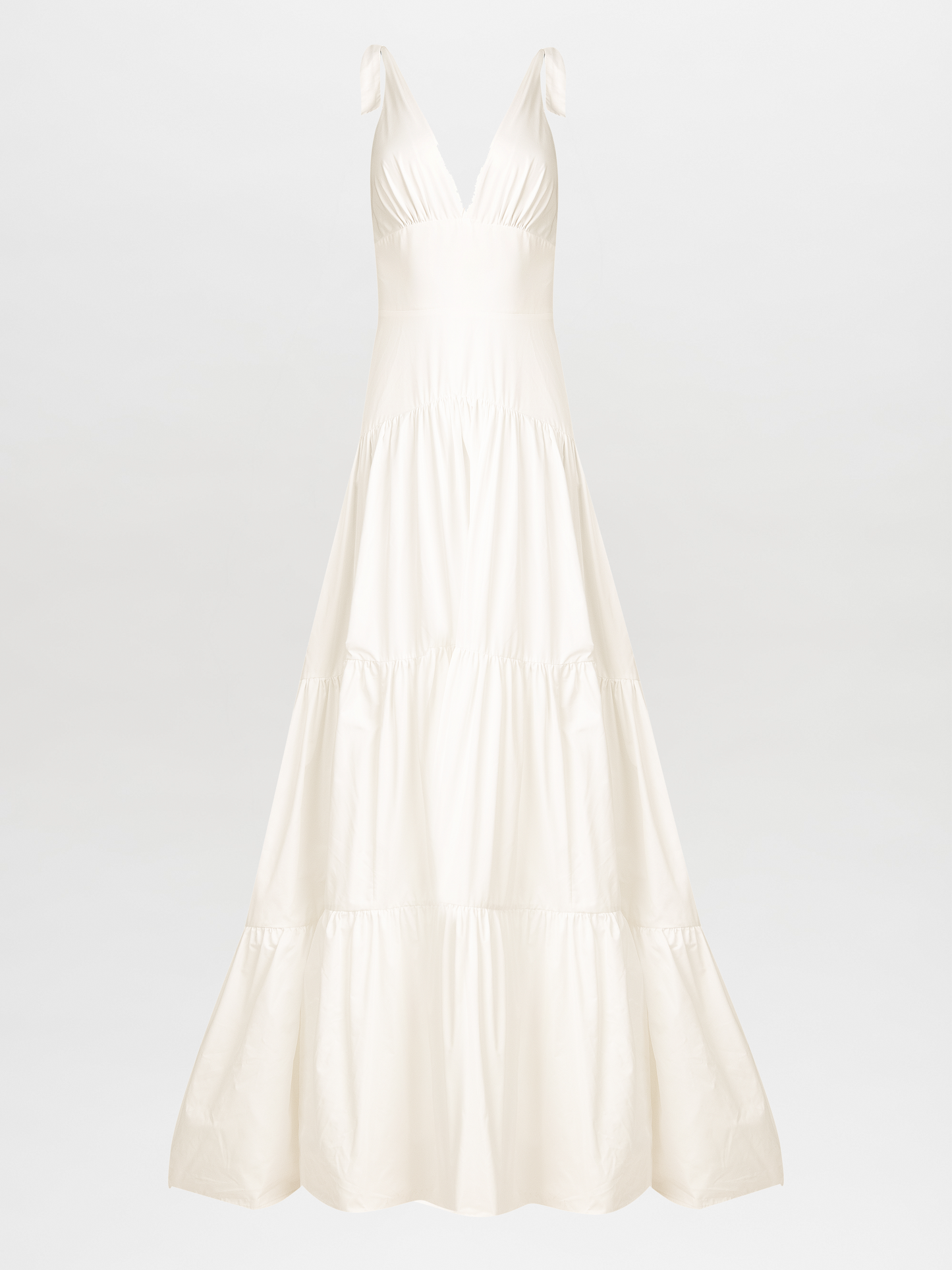 The Terracina Dress White is a sophisticated sleeveless, full-length gown with a V-neck and tie straps, ideal for formal events. It elegantly showcases a multi-tiered skirt against a plain white background.