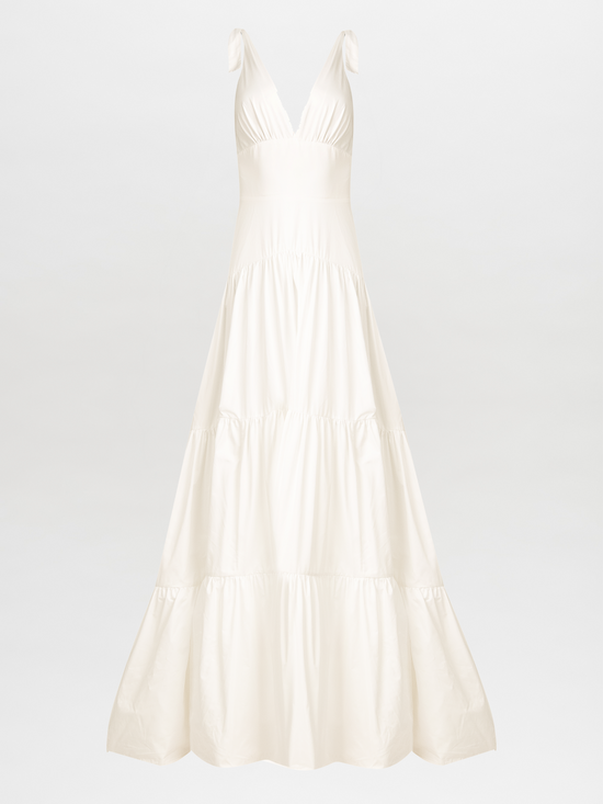 The Terracina Dress White is a sophisticated sleeveless, full-length gown with a V-neck and tie straps, ideal for formal events. It elegantly showcases a multi-tiered skirt against a plain white background.