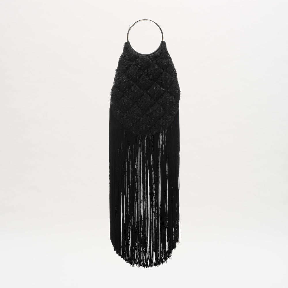 The Toblach Bag is a black quilted handbag made from Austrian fabric, with metallic top handles and long straight fringe at the bottom, shown against a plain white background.