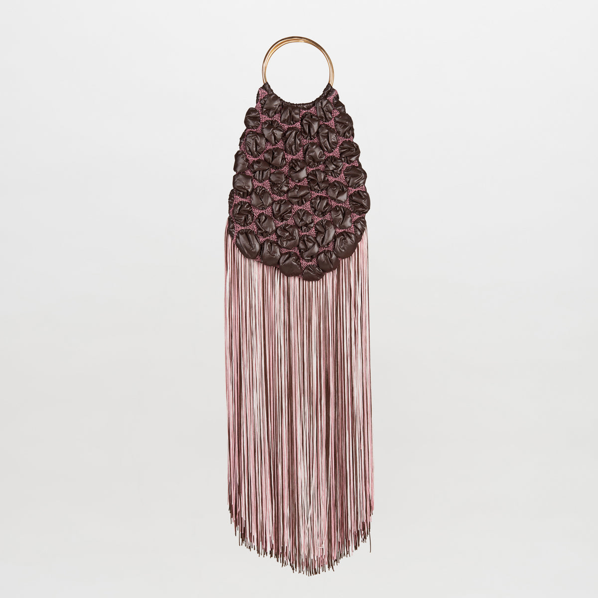 The Toblach Bag is a dark brown handbag featuring a quilted, gathered texture and long, tiered pink fringe, hanging from circular metallic handles.