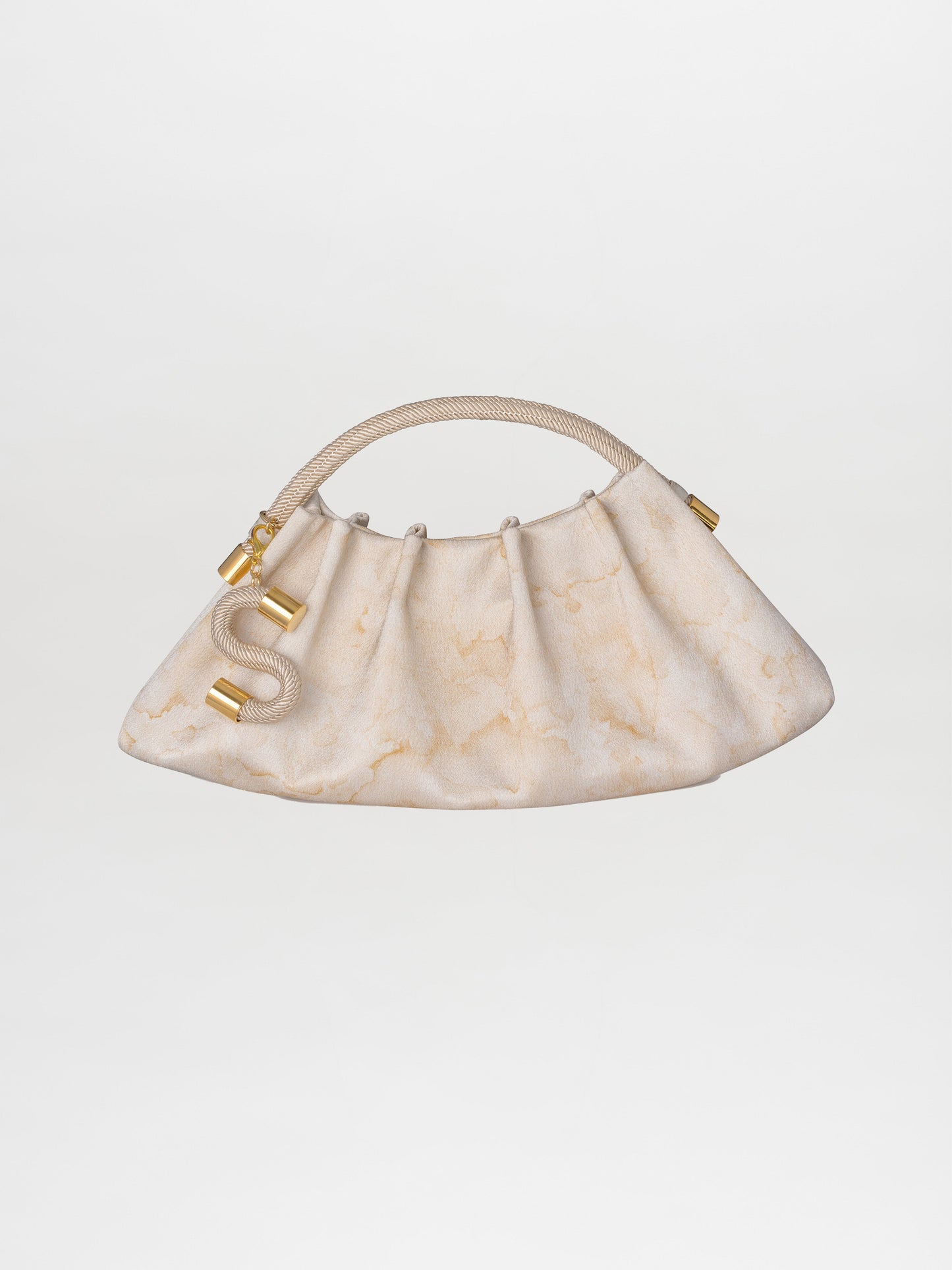 The Trapezius Clutch Cream, featuring a cream-colored pleated design with gold hardware and a looped rope handle, is elegantly showcased against a plain background.