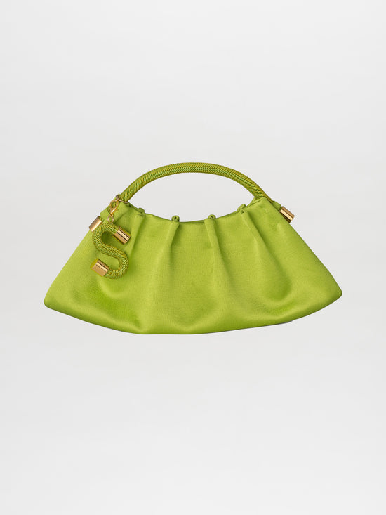 Introducing the Trapezius Clutch Lime: a pleated clutch crafted from crepe fabric, showcasing a vibrant green color and an organic, unique shape with a curved handle. It is elegantly adorned with gold accents and features a stylish S-shaped charm.