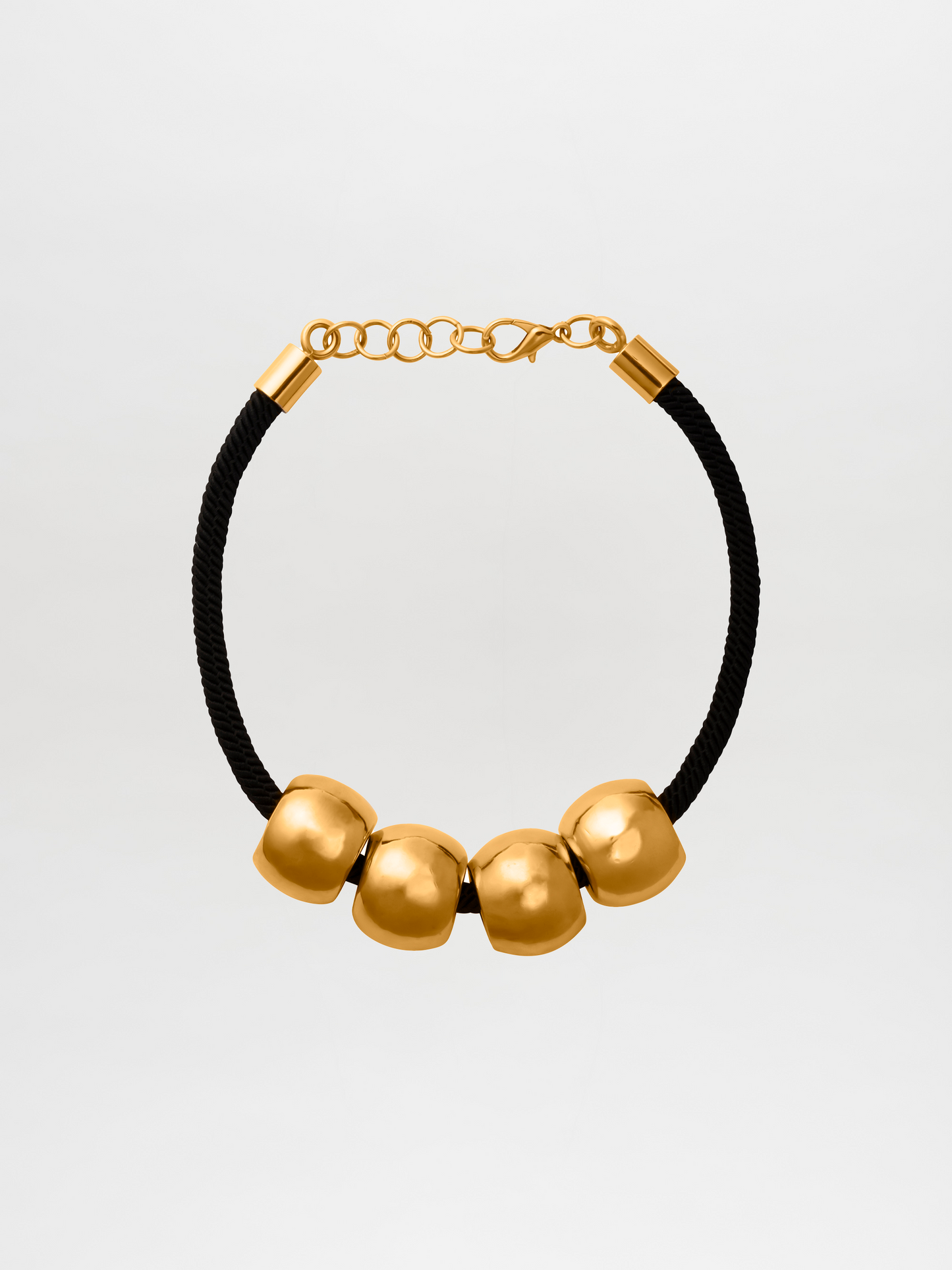 A Tristana Necklace Black with four large gold beads and an adjustable gold clasp, available for pre-order now with a ship date in early 2024.