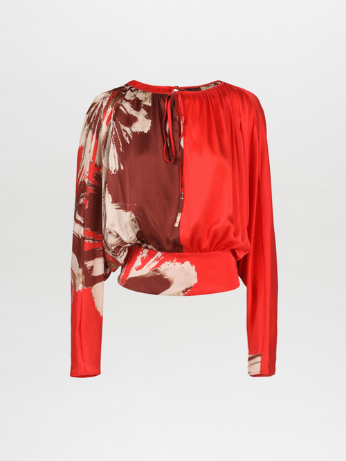 The Tyne Blouse Scarlet Brown Floral is a long-sleeve silk blouse that showcases an abstract floral brushstrokes print, complete with a tie closure at the neckline and a gathered waist.