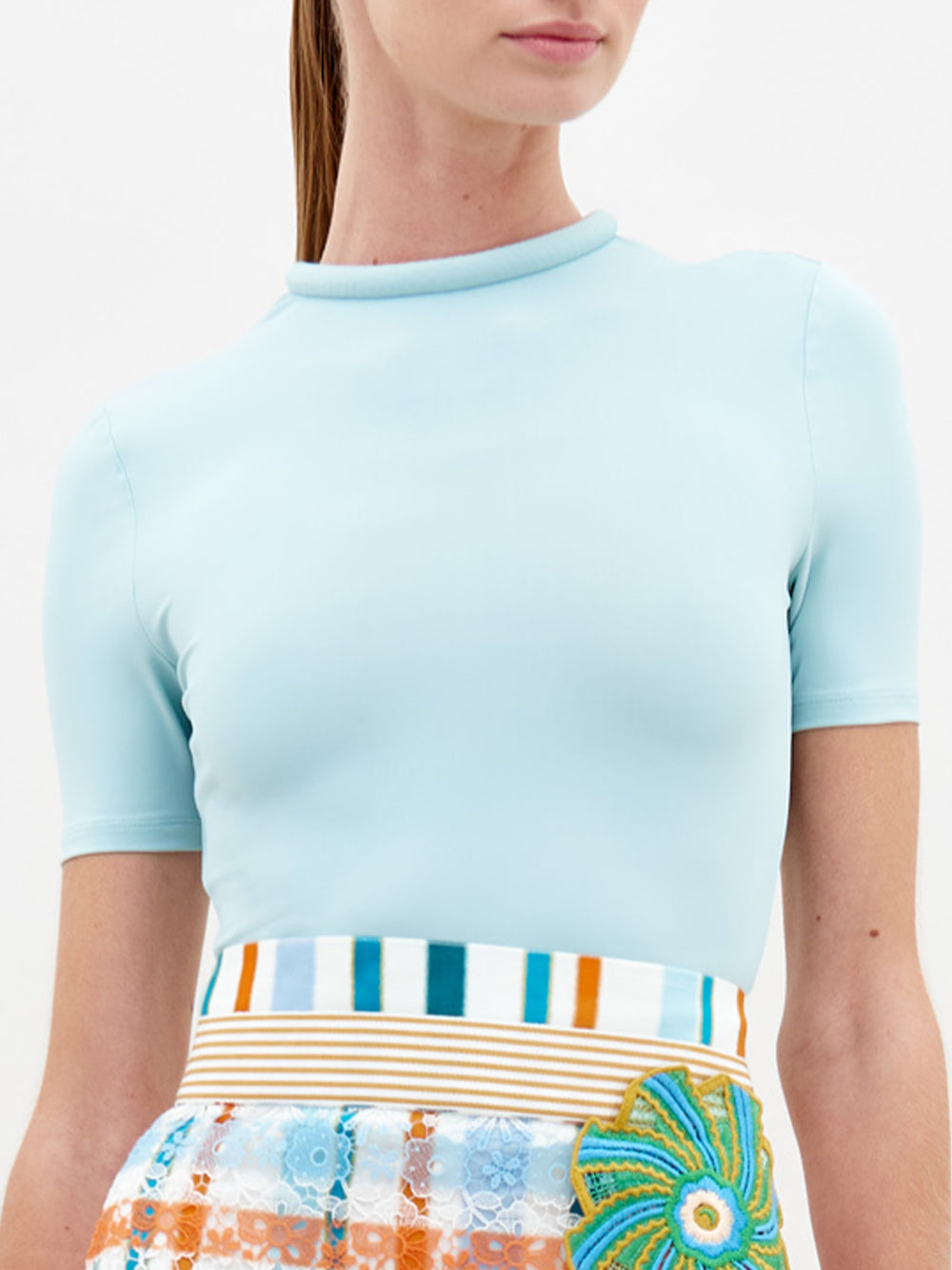 A person wearing the Varinia Tshirt in color Turquoise on a white background.