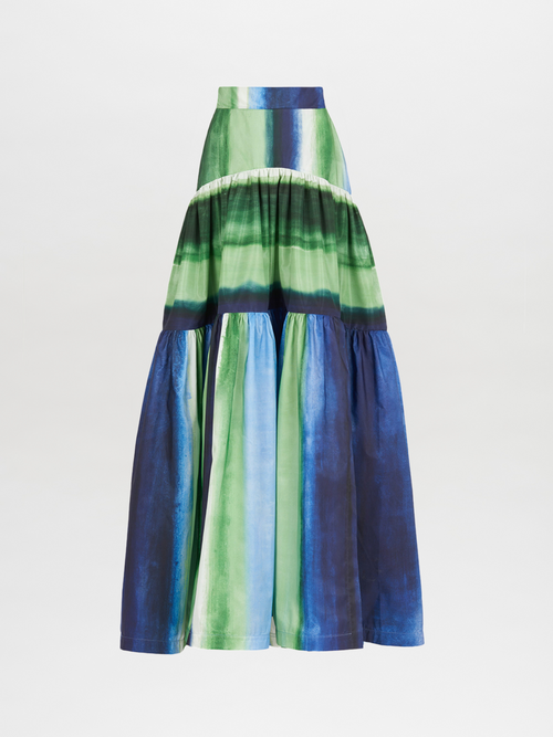 The Nieves Top Washed Emerald Blue is an off-the-shoulder blouse featuring abstract patterns, large, puffed sleeves, and subtle brown stripes in shades of blue and green.