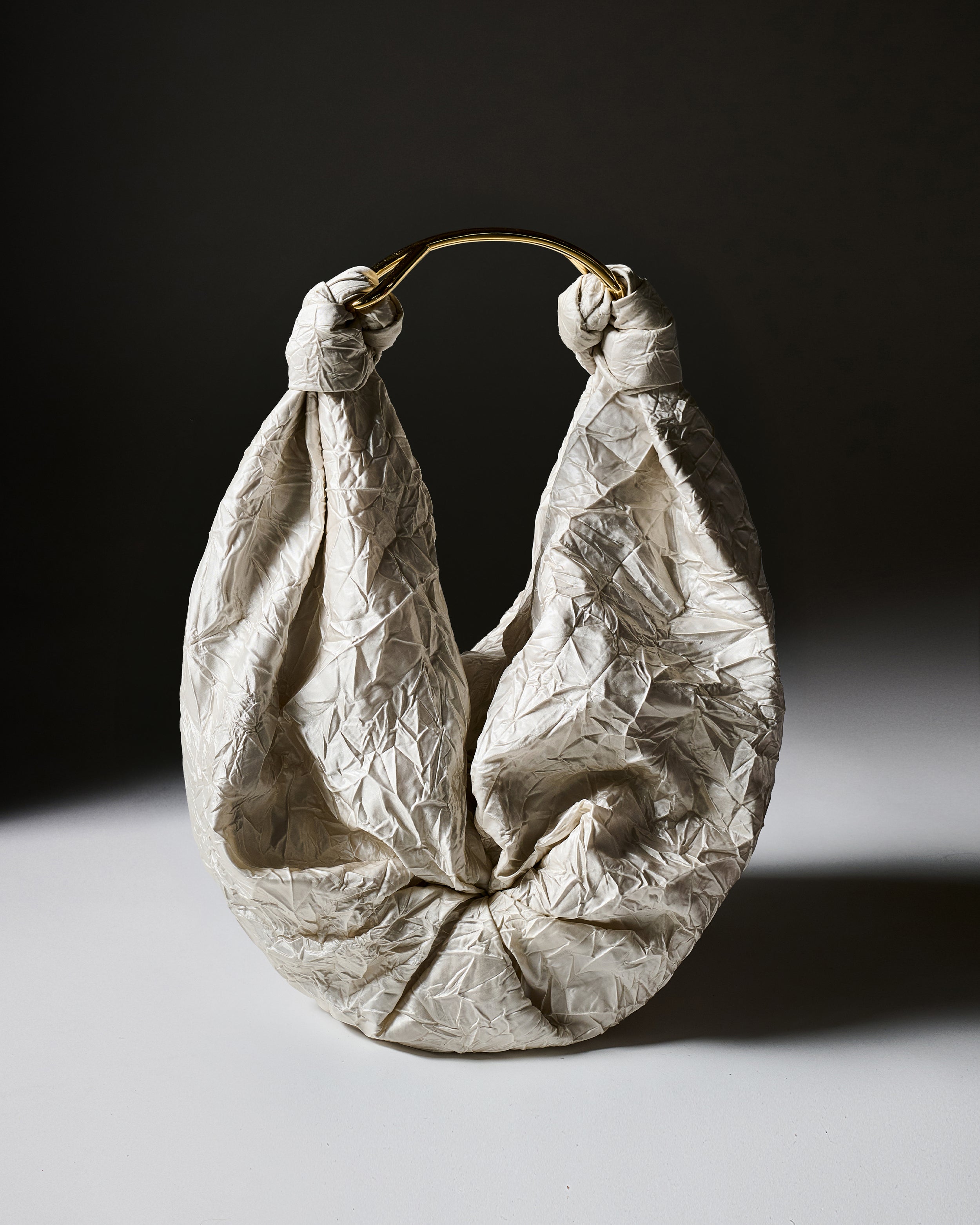 Textured off-white Sofia Bag on a dark background