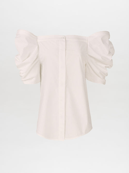 The Wynn Blouse White with voluminous puff sleeves and a central button closure on the front, crafted from lightweight cotton.