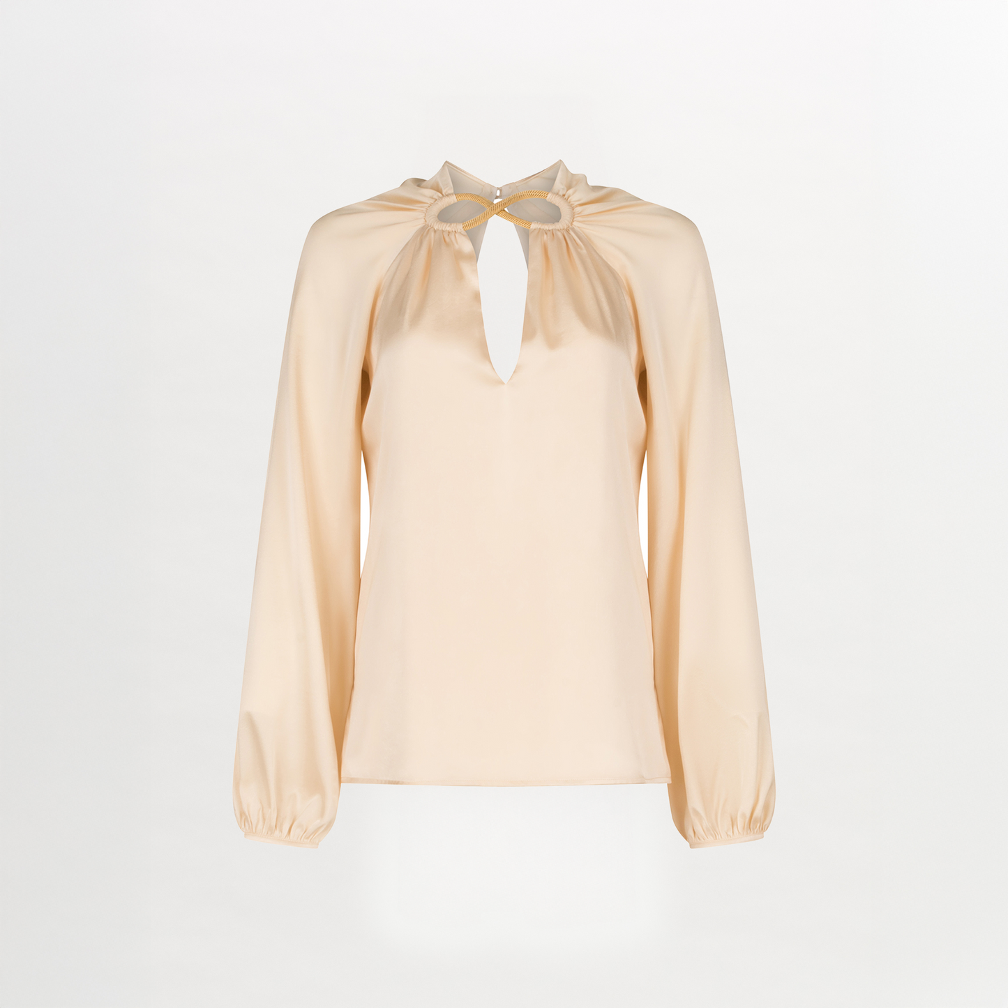 A Ximena Blouse Beige with a ruffled neckline and metallic detailing.