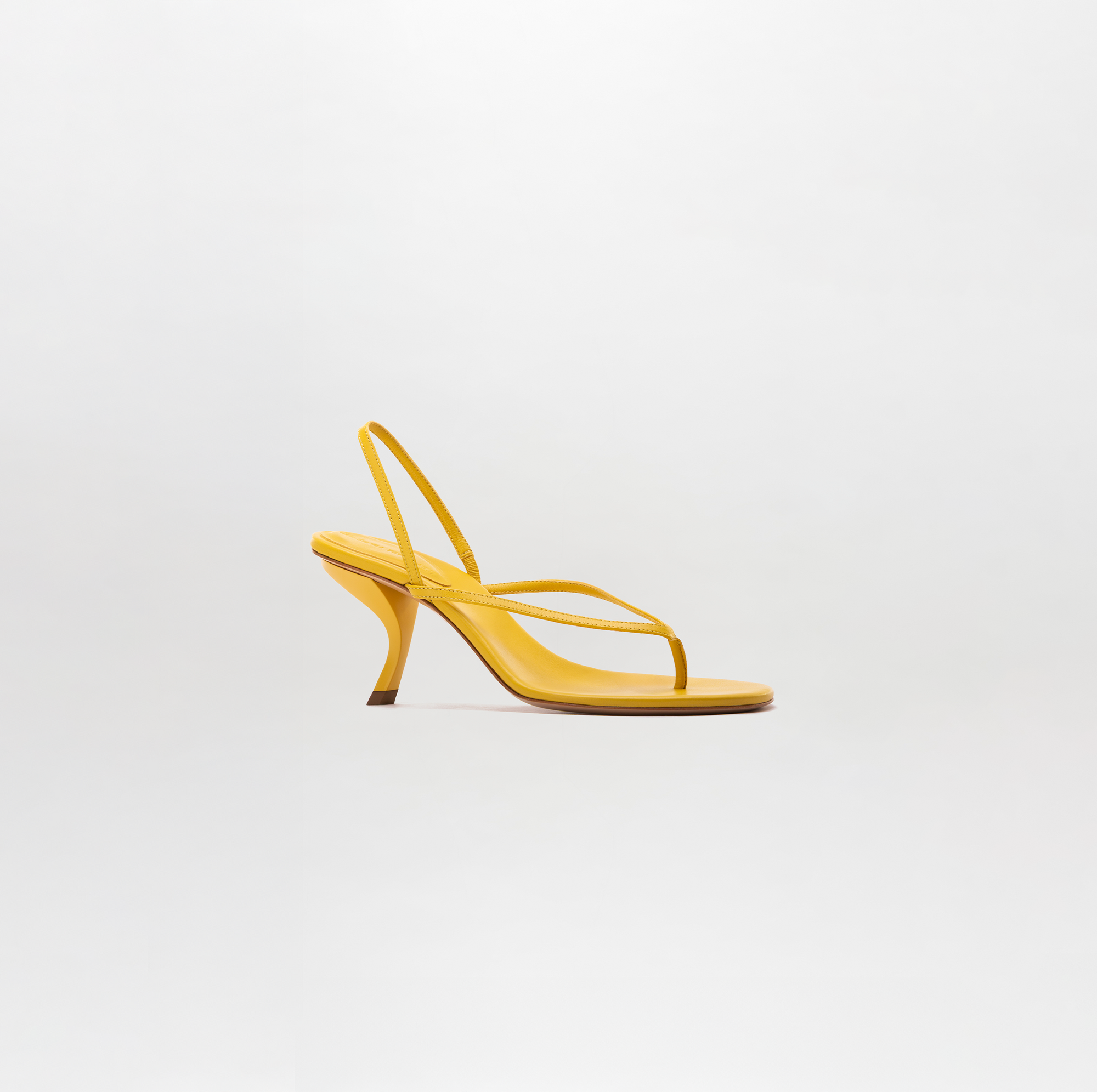 Yellow high-heeled sandal on a light gray background