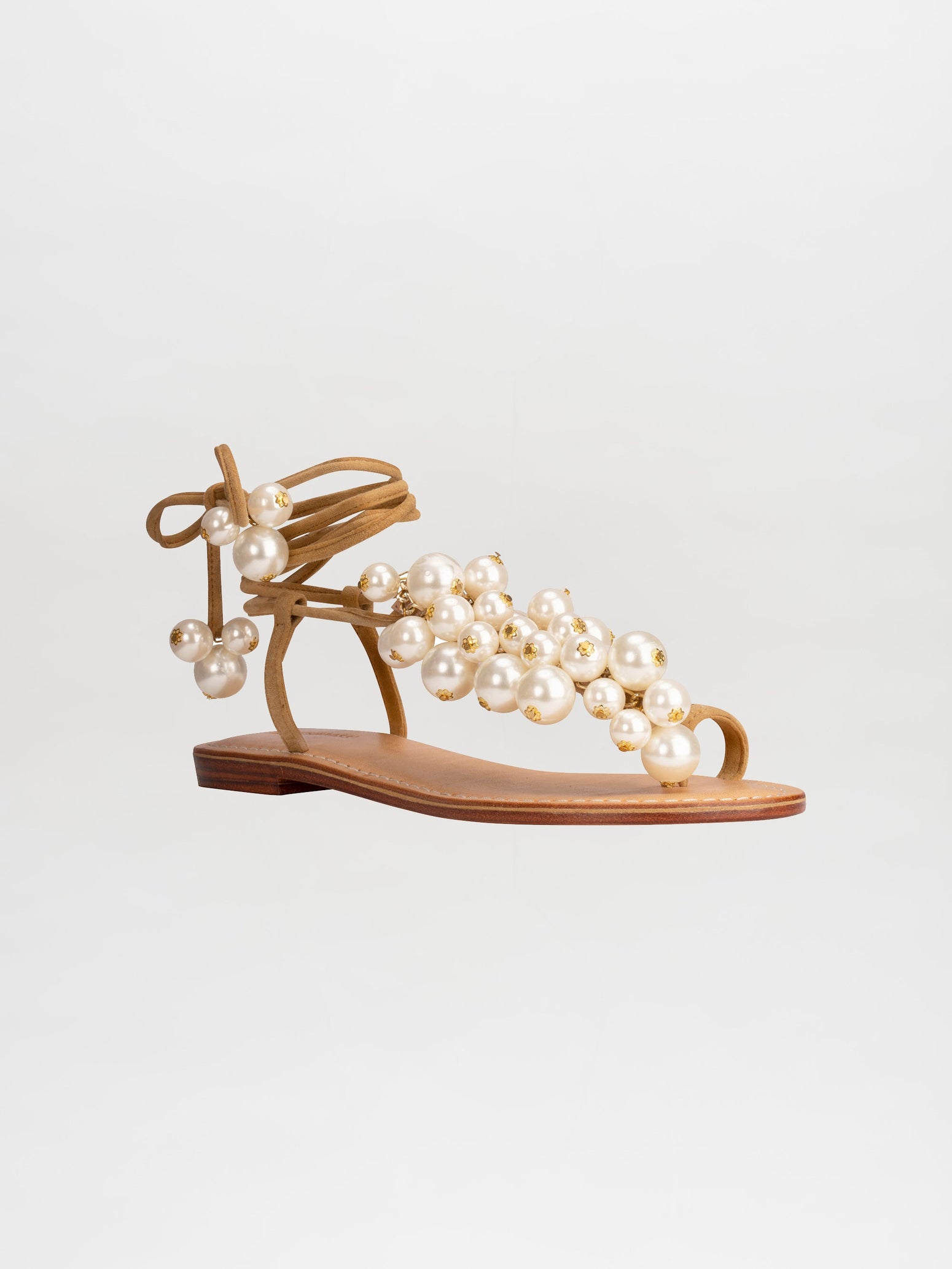 Presenting the Zaira Sandals Camel: a single tan sandal with a flat sole, adorned with multiple pearl-like beads and an ankle tie strap, displayed on a white background. Now available for pre-order; secure yours today and enjoy exclusive shipping by February 15th, 2025.