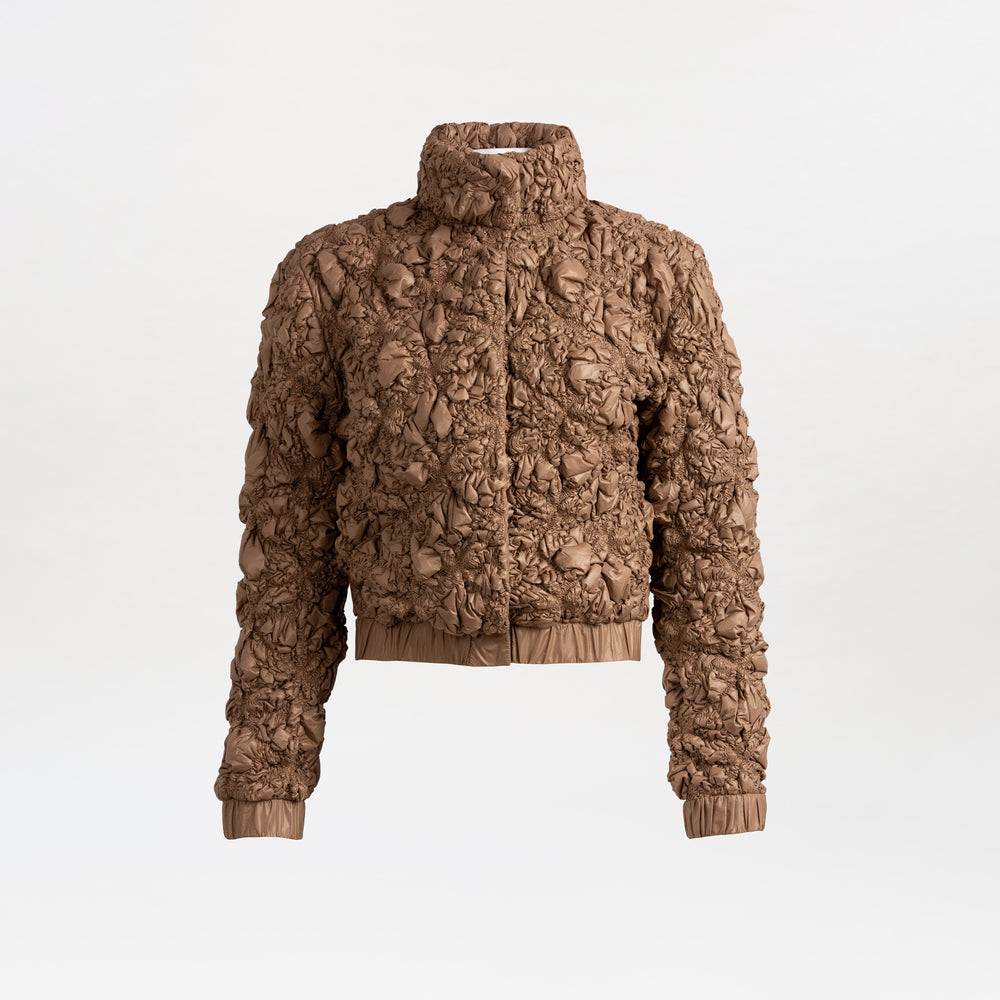 The Zalta Jacket is a brown, textured cropped piece with a high collar, crinkled ruched Italian fabric, long sleeves, and elastic cuffs and hem, shown against a plain white background.