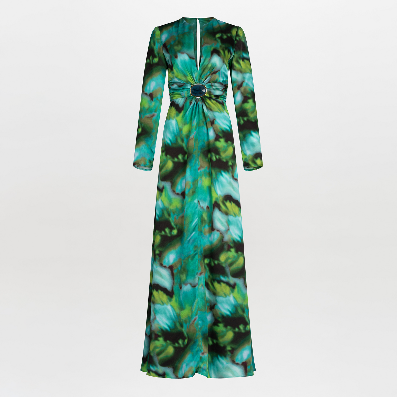 A person wearing the Zarina Dress Juniper Green, made of 100% silk, featuring a green and blue abstract multicolor print with a deep neckline and a central decorative brooch.