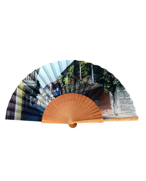 The Abanico Balcones is an ornamental fan showcasing a scenic view of a street lined with buildings and lush greenery.