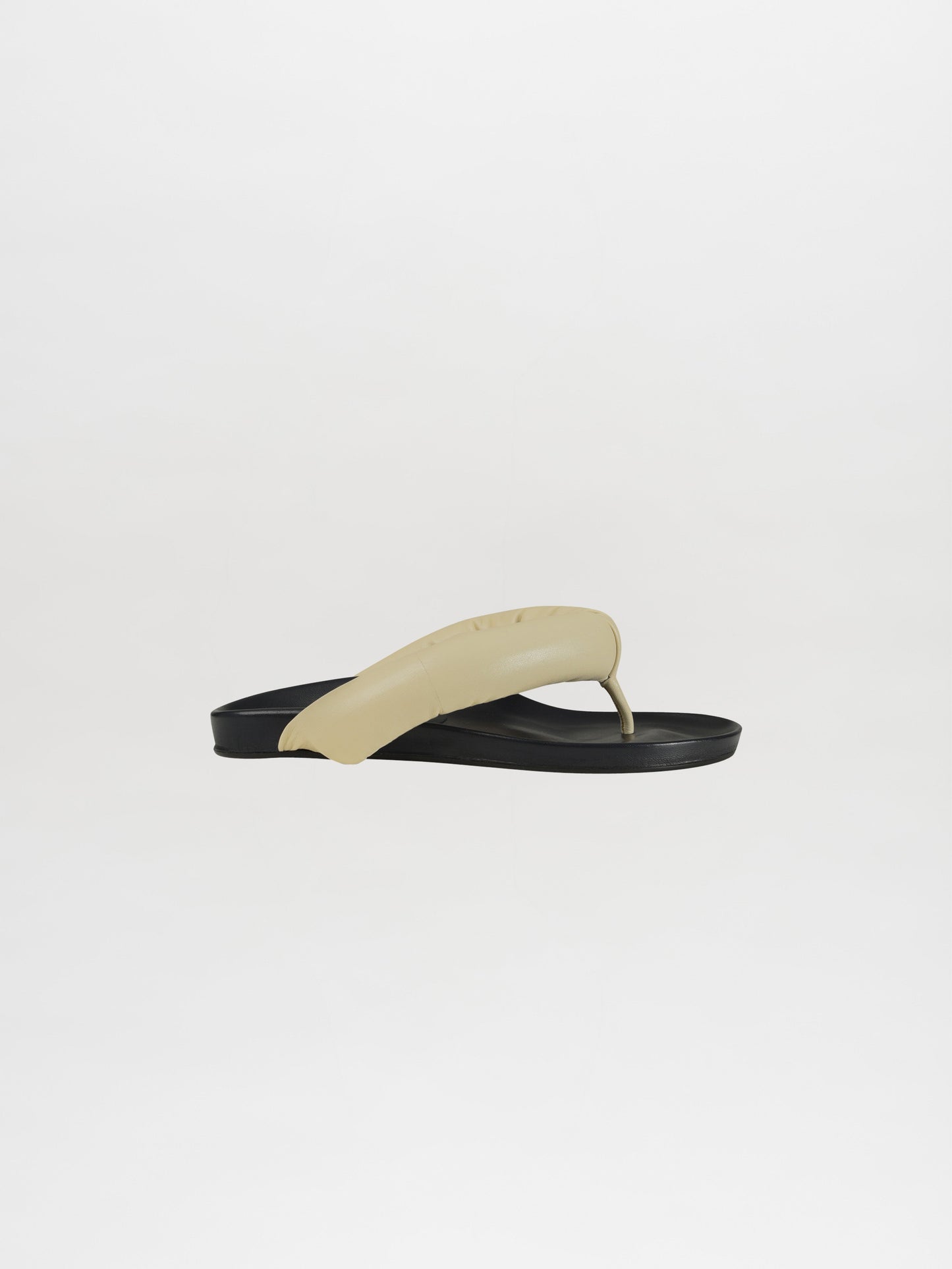 A single, fashion-forward Giacomo Sandal Ivory flip-flop stands against a plain white background, highlighting its sleek design.