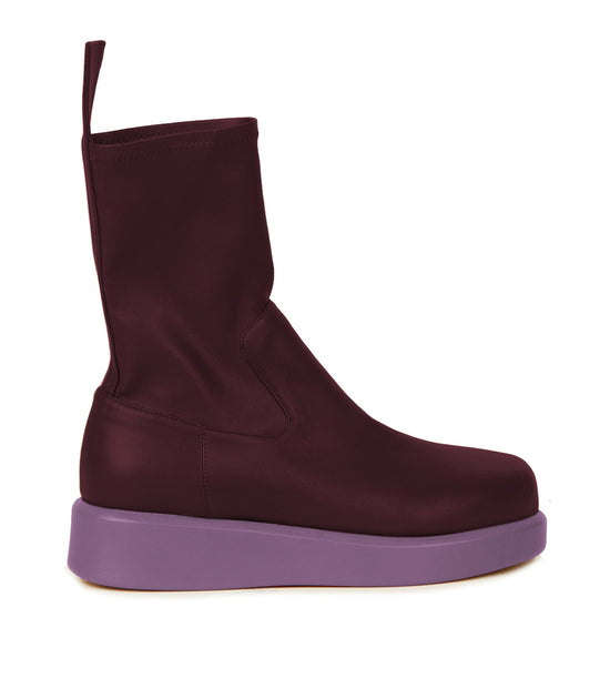 The Baia Boots Lillac by Silvia Tcherassi feature a maroon high top design crafted from soft stretch calf leather, complemented by a thick light purple sole, viewed from the side against a white background.