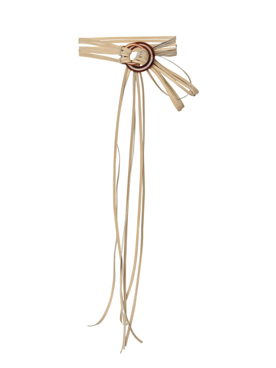 The Milca Belt Pearl, crafted from exquisite Italian leather, features a tan color with multiple long, thin straps extending from a round, intricate knot design at the center. This statement piece is perfect for adding an elegant touch to any outfit.