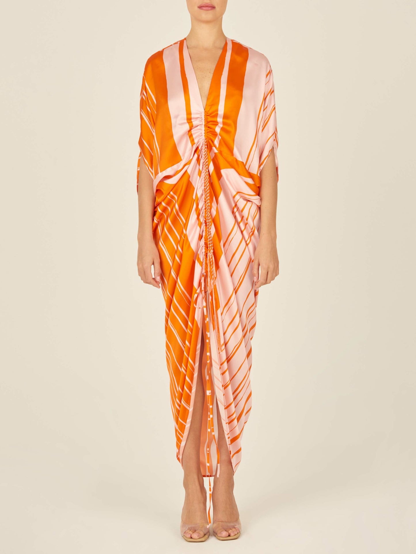 An Cloister Dress Orange Pink with a festive print on a mannequin.