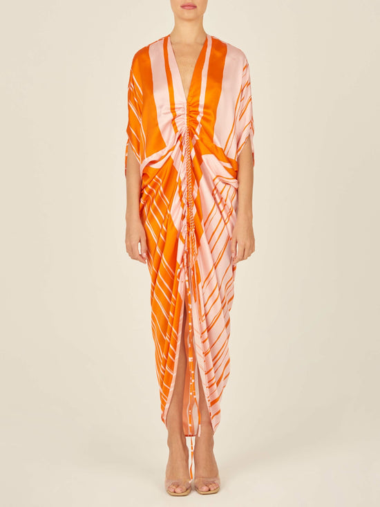 An Cloister Dress Orange Pink with a festive print on a mannequin.