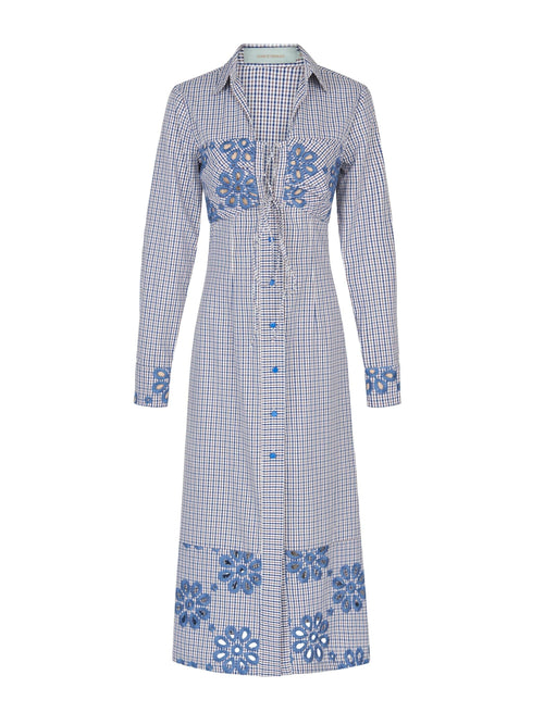 The Ganzoni Dress Navy Floral is a long-sleeve, button-down dress with a collar, featuring a blue and white checkered pattern and blue floral designs. This item is part of our Final Sale and is not eligible for return or exchange.