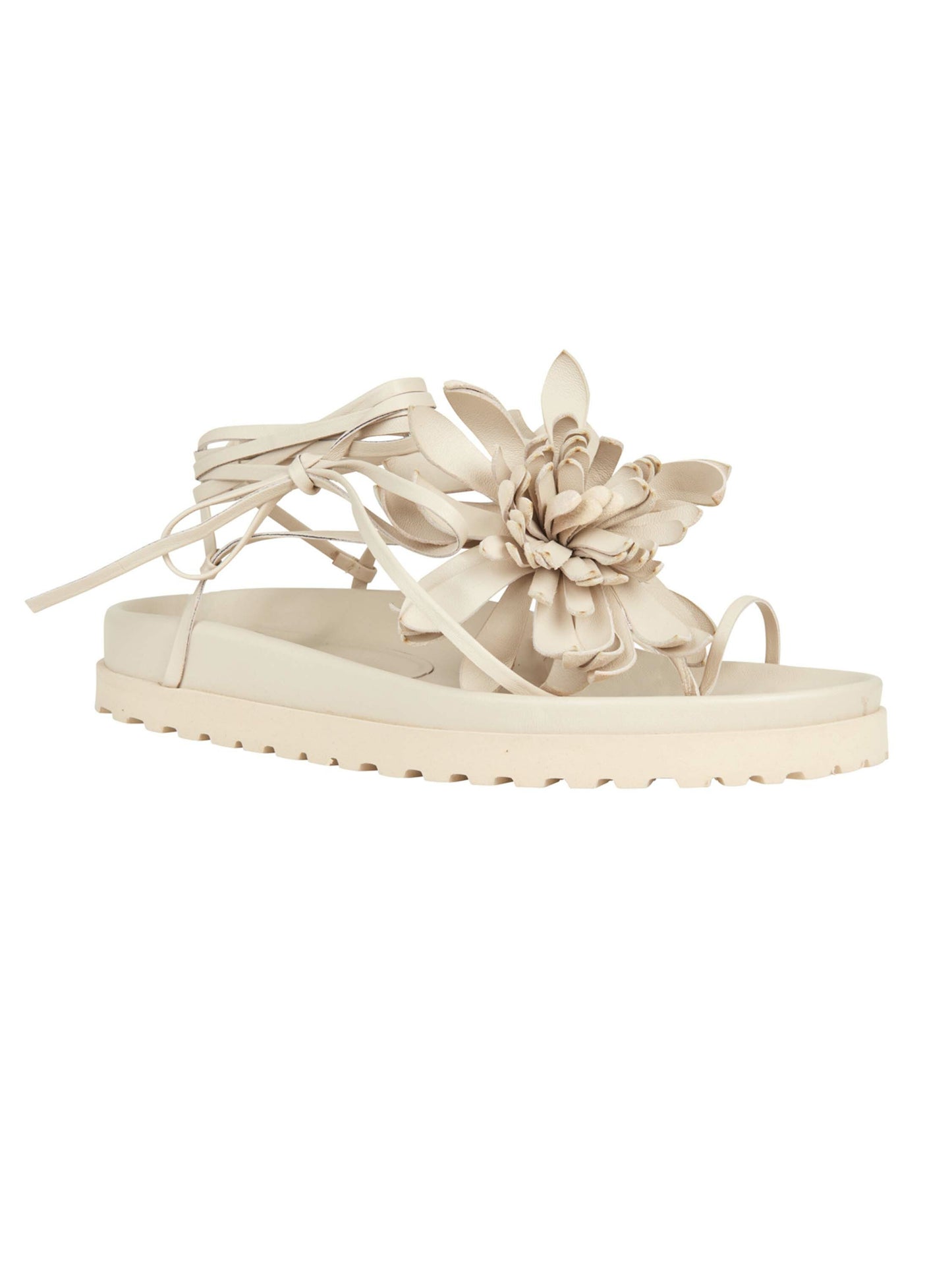 Idania Sandal Beige with a large floral decoration and lace-up ties, ready to order on a white background.