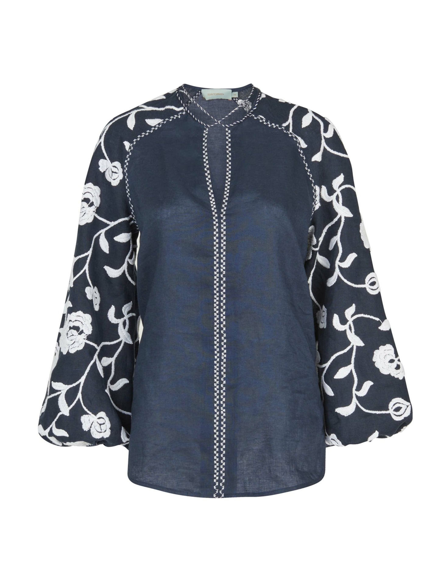 A Molveno Blouse Navy Embroidered with white flowers embroidered on high-fashion sleeves.