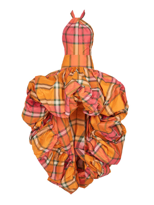 A mannequin dressed in an orange plaid taffeta garment with a large, ruffled skirt section, showcasing an Eloina Dress Ultra Orange.