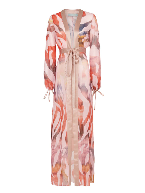 Long-sleeved, pink, and beige patterned robe with a sash belt and wide lapels. The Magdalena Dress Blush Prismatic features abstract zebra print brushstroke designs and tie detailing on the sleeves.