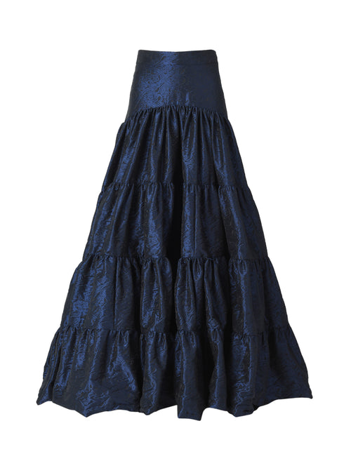 The Damiano Skirt features a dark blue jacquard pattern with a high waistband and a tiered maxi length.