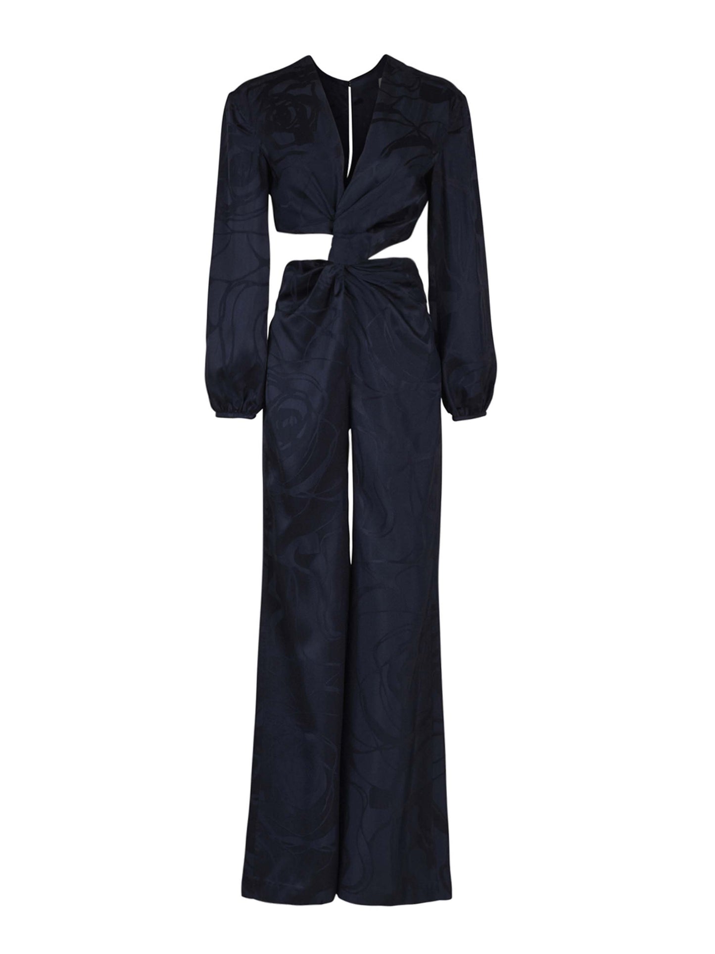 The Joely Jumpsuit Navy Jacquard, a black long-sleeve piece from the Resort 2023 collection, features a twisted front design, cutout at the waist, and wide-leg trousers.