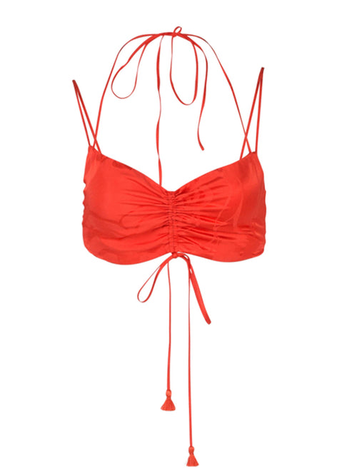 The Kayla Top Crimson Jacquard is a cropped camisole with thin straps and a halter neck tie, featuring ruching detail at the front and long tassel ties hanging down.