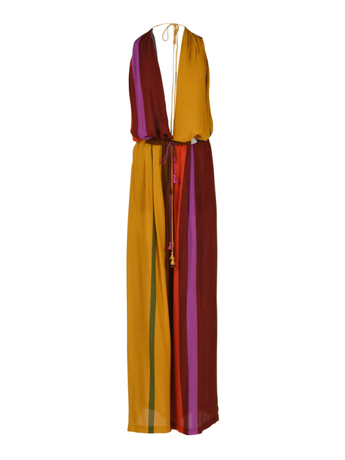 The Shelley Jumpsuit Color Block Multi is a sleeveless, halter-neck piece crafted from viscose, featuring vertical stripes in shades of mustard, maroon, red, and purple. It boasts a tie at the waist and an open back.