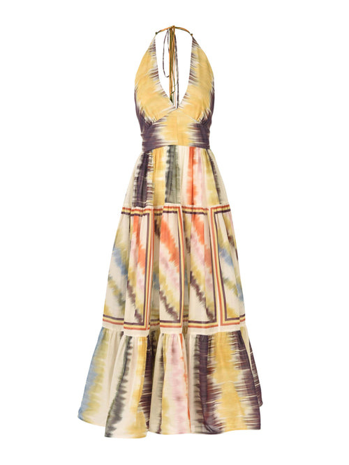 The Valerie Dress Multi Hazy Stripe is a sleeveless halter-neck midi dress featuring a vibrant multi hazy stripe tie-dye pattern and a charming tiered skirt.