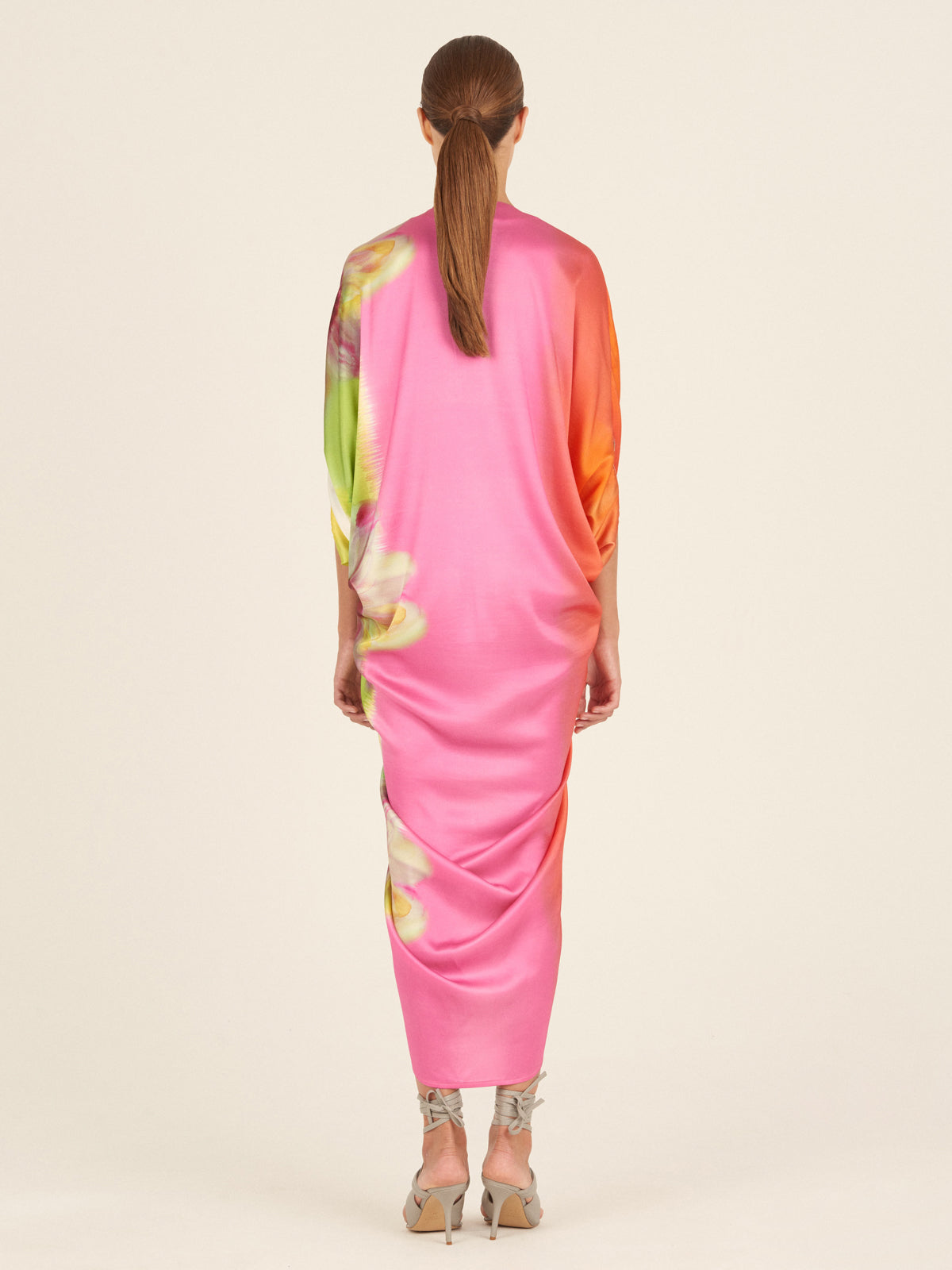 A versatile, colorful silk scarf with a Cloister Dress Floral Gradient Rainbow print on a mannequin.