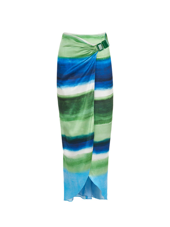 A long skirt with a tie-dye pattern in shades of blue and green, featuring a wrap design and a belt buckle detail at the waist. The Adrianne Skirt Washed Emerald Blue is final sale and not eligible for return.