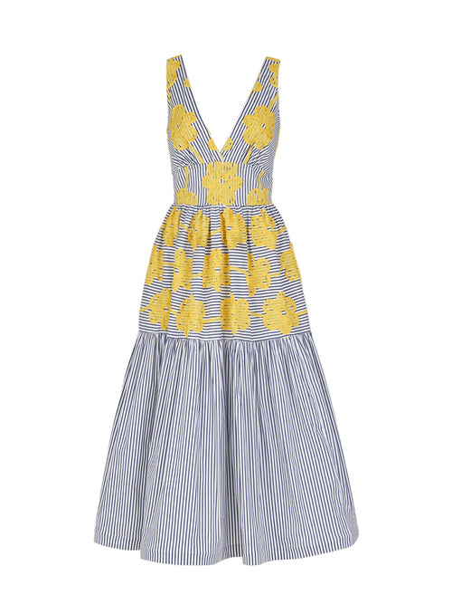 The Eugene Dress, adorned with yellow floral embroidery, showcases a sleeveless design with blue and white vertical stripes, a V-neckline, and a long-tiered skirt.