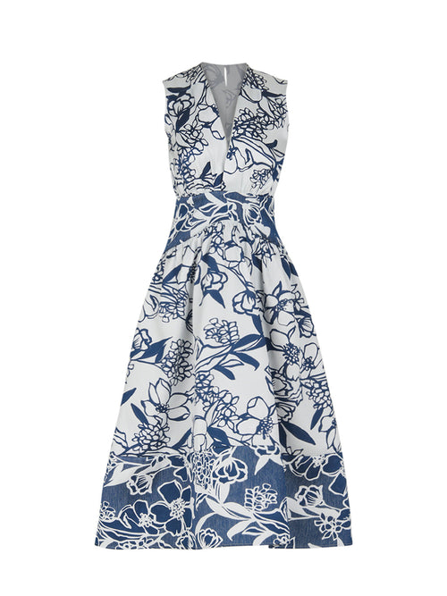 The Nayla Dress Navy Whimsical Garden is a sleeveless white dress with a deep V-neck and a flared skirt, boasting a blue floral print and a charming retro silhouette.