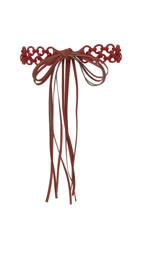 A decorative, red knotted Sindione Belt Red with long, hanging strands features intricate resin rings. Final sale item.