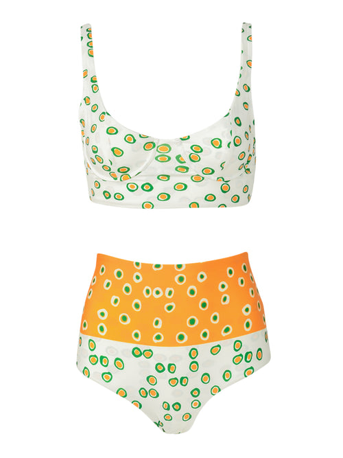 The Trancoso Top and Hilaria Bottom set features a two-piece design with a scoop neck top and high-waisted bikini bottoms. The swimsuit is white with green and yellow circular patterns, while the bottom half showcases an orange section adorned with matching patterns.